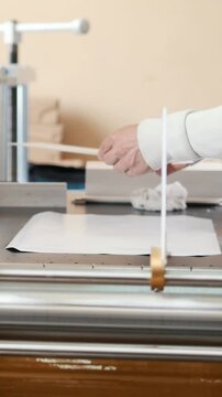Worker works at polygraph machine, printing industry
