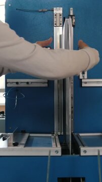 Worker inserts sheets of paper to printing machine, polygraph industry