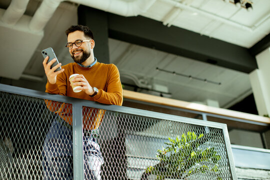 Enjoying a moment of joy while checking messages in a modern cafe setting
