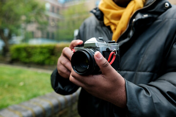 Fototapeta premium Person holding vintage slr camera outdoors for street photography