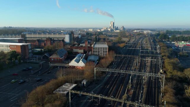 Aerial drone view of large railway tracks and industrial factories on the West Coast Main Line in Rugby UK.