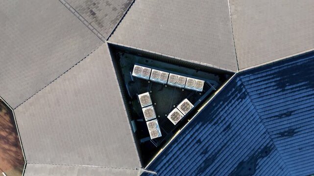 Symmetrical aerial perspective of a triangular office building roof with industrial air conditioning units and ventilation infrastructure.