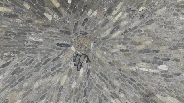 Cobblestones laid in a pattern that converges in a circle toward a single point, Zoom in shot