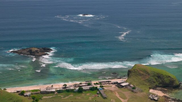 tropical coastline with reef waves rocky islets sandy beach and small coastal village Scenic ocean landscape with turquoise water surf grass covered hill and remote shore coastal geography, ocean land
