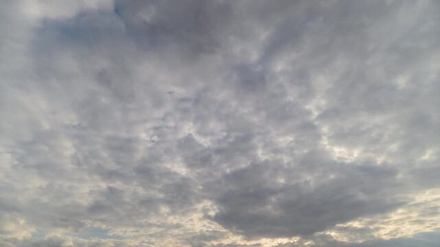 Slow moving clouds under peaceful pastel sky enjoy serene passage. Panoramic drone perspective reveals calm clouds gradually shifting over muted horizon with soft glow