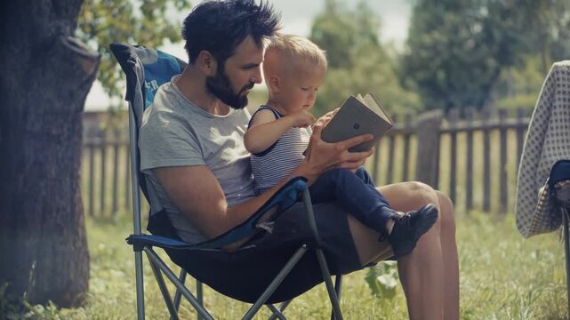 Father Reading Book To Little Son. Family Education. Relational Bond And Childhood Development