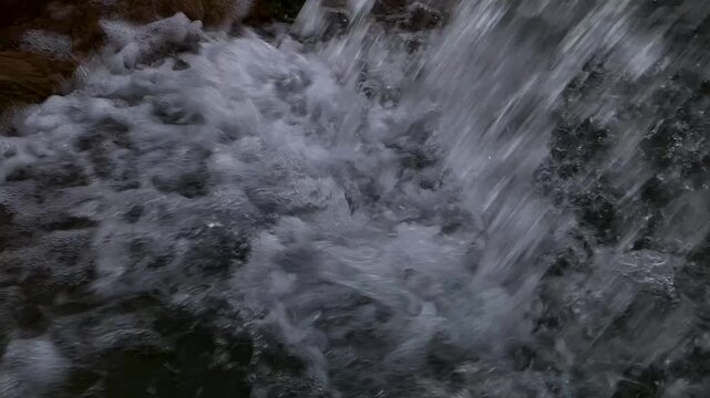 Dramatic Close-Up of Rushing Waterfall with White Foam and Bubbles in 4K