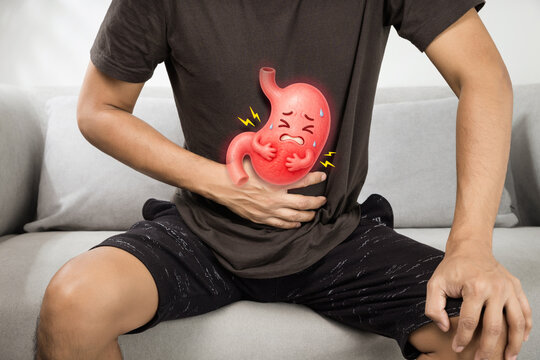 A man sits gripping his abdomen as a cartoon stomach shows pain, illustrating gastritis, acid reflux, and digestive issues linked to stress, diet, and modern lifestyle habits in daily life