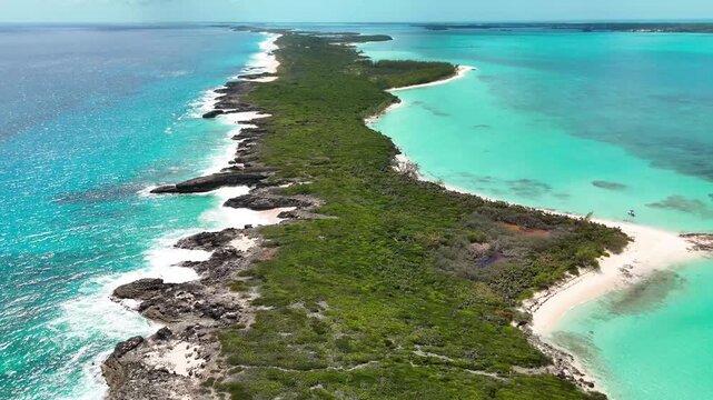 Aerial view of Stocking Island with lush green vegetation, rocky coastlines, and turquoise waters in George Town, Exuma, The Bahamas.