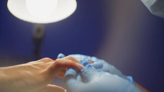 Skilled manicurist working on client nails in salon environment highlighting hygiene precision and cosmetic hand care procedure. High quality 4k footage
