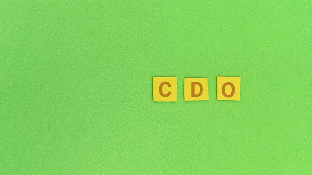CDO abbreviation formed by letter tiles on a vibrant green background