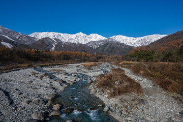 紅葉の山と冠雪の北アルプス　長野県白馬村 © RATM