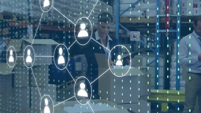 Diverse team with mature woman lead checking boxes and using tablets with data overlay at warehouse