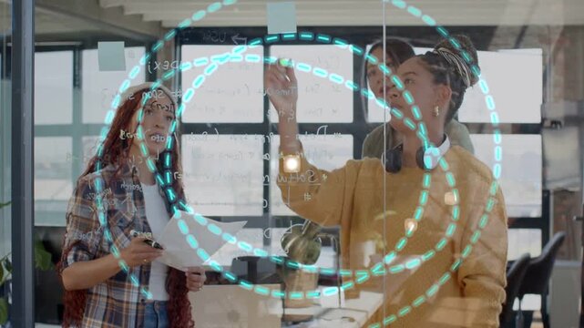 Team marking glass, placing sticky notes, marker causing turquoise circle growth for product plan