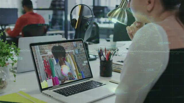 Woman leaning, watching laptop showing live fashion demo, tracking striped top for design review