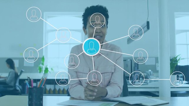 Presenter at desk clasping hands as tech network appearing, gesturing to blue node linking users