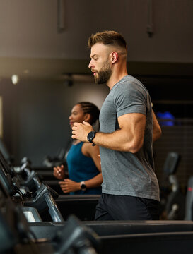 Portrait of a young man and a black woman exercising in a gym, running using  thereadmill machine equipment, healthy lifestyle and cardio exercise at fitness club concepts