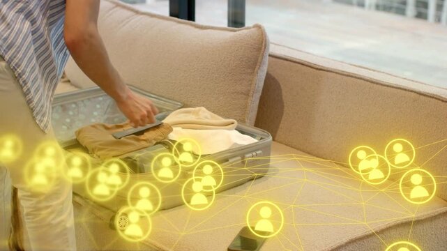 Man leaning over suitcase, packing for business trip while glowing network overlay tracking phone