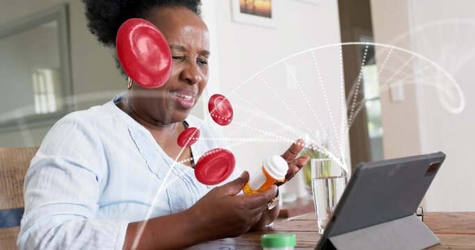 Holding pill bottle, woman in light blue blouse consulting tablet at home, red graphics and water