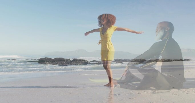 Standing woman in yellow dress reaching arms at shore, sitting man in dark jacket double-exposure