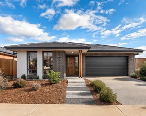 Fototapeta premium Modern home with stone and wood accents, blue sky