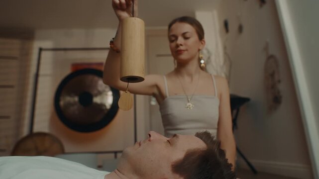 Sound healing session with singing bowl above lying person