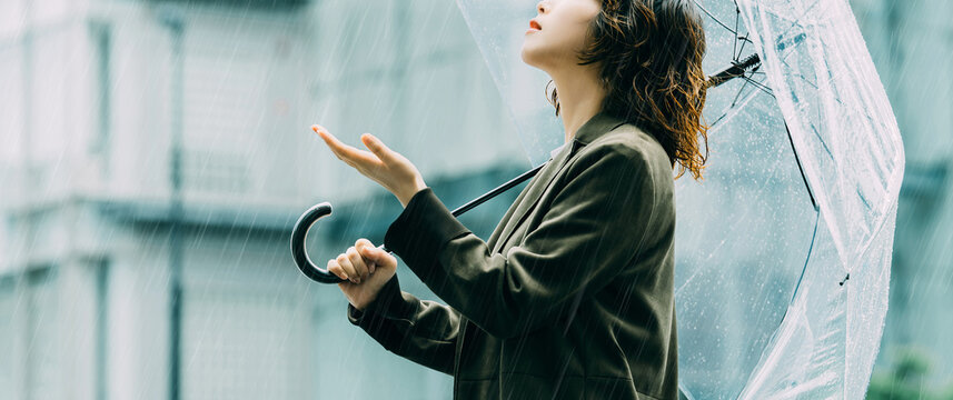 雨の日に傘をさす日本人女性・ビジネスウーマンのイメージ（LP・バナー向け）, Japanese Businesswoman with Umbrella on Rainy Day