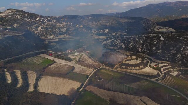 Aerial View of Wildfire Flames and Smoke Over Rugged Hillside Near Omodos Village Cyprus