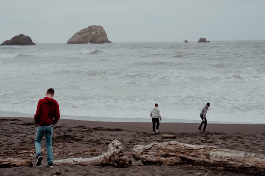 3 young men walking on the beach