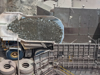 Huge Caex dump truck pouring rocky material into primary crusher at mine © WILL PHOTOGRAPHY