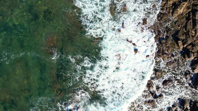 Aerial drone footage of the Normandy coastline in France, showcasing dramatic cliffs and ocean waves along the English Channel. Scenic coastal landscape captured from above, ideal for travel, nature, 
