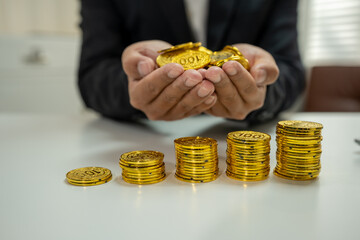 Fototapeta premium Businessman calculating rising costs with gold coins, inflation and financial growth concept.