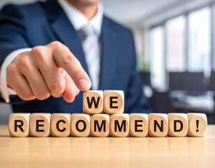 Obraz premium We Recommend! - Geschäftsmann zeigt auf den Text 