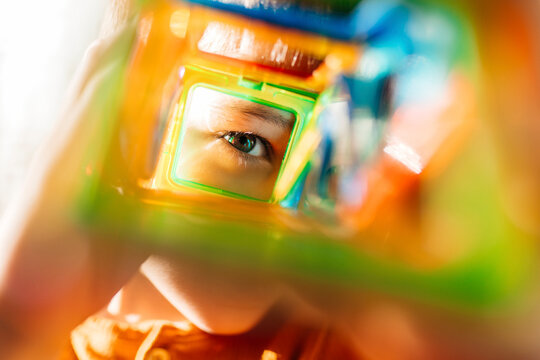 Eye looking through colorful constructor toy showing curiosity