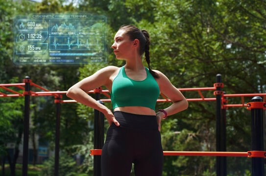 Active woman analyzing holographic fitness data outdoors in park