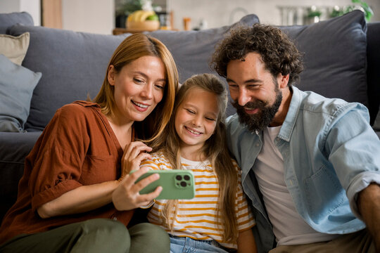 Family taking selfie and laughing together in living room