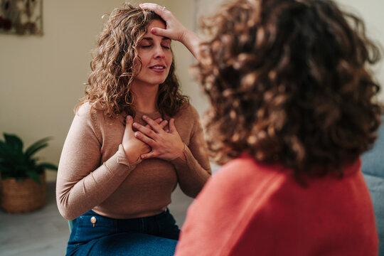 Healing session with woman experiencing emotional release indoors