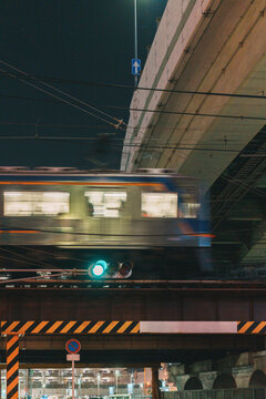 Motion blur of a train passing under an elevated highway at night