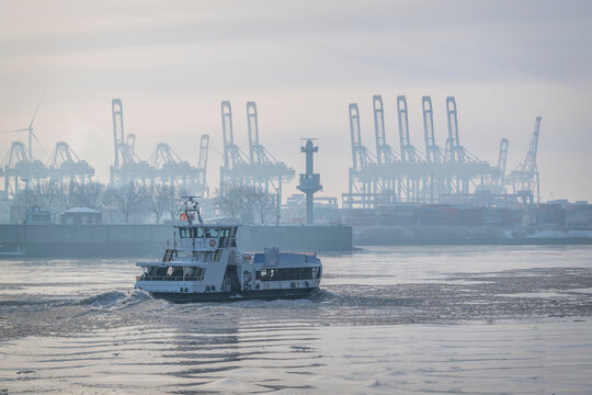 Ferry boat sailing on icy river in Hamburg harbour during winter