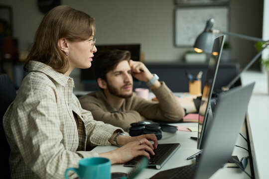 Colleague helping coworker at computer in the office