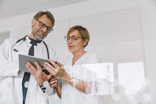 Doctors looking at digital tablet during hospital consultation