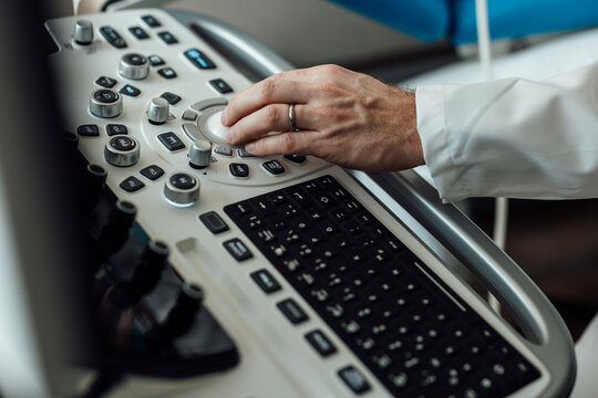 Doctor hand operating ultrasound machine panel at the hospital