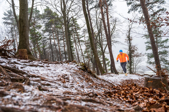 Trail running in a snowy forest during winter training session