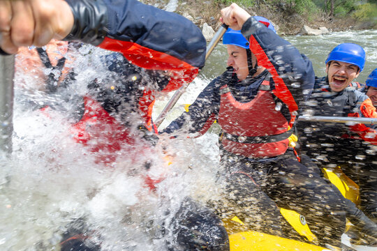 Rafting - splashing water is aiming for the boat of rafters in a river