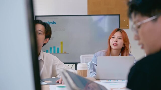 Asian businessman listening in team meeting discussion in modern office