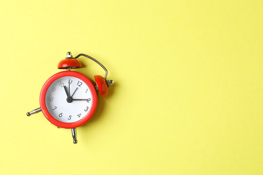 One red alarm clock on bright background, top view