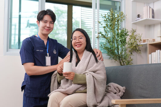 Asian man caregiver and woman patient in blanket for home comfort