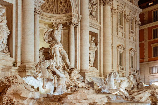 Trevi Fountain showcasing its iconic Baroque architecture and intricate sculptures, with the majestic Oceanus chariot and seahorses illuminated at night in Rome, Italy