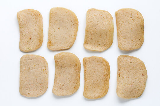 Raw and uncooked prawn or shrimp crackers, isolated on a white background.