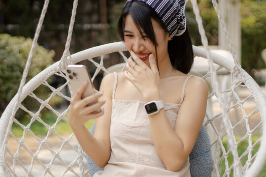 Laughing Woman Watching Funny Content on Smartphone Outdoors